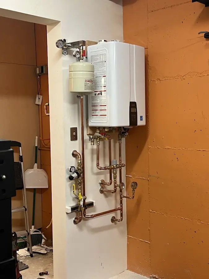 Plumbing technician inspecting water heater connections in Sanford